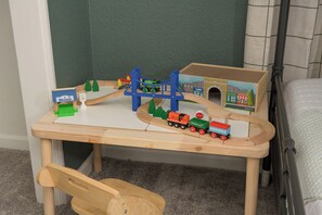 A wooden play table with a train set and a toy cityscape. - Stay Golden! ☀Family Retreat☀ New Hot Tub! + Sleeps 12 (Wheat Ridge)