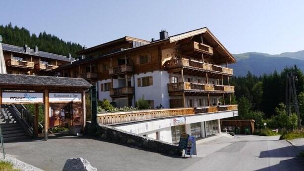 Un edificio a più piani con balconi, un ristorante e un bar.