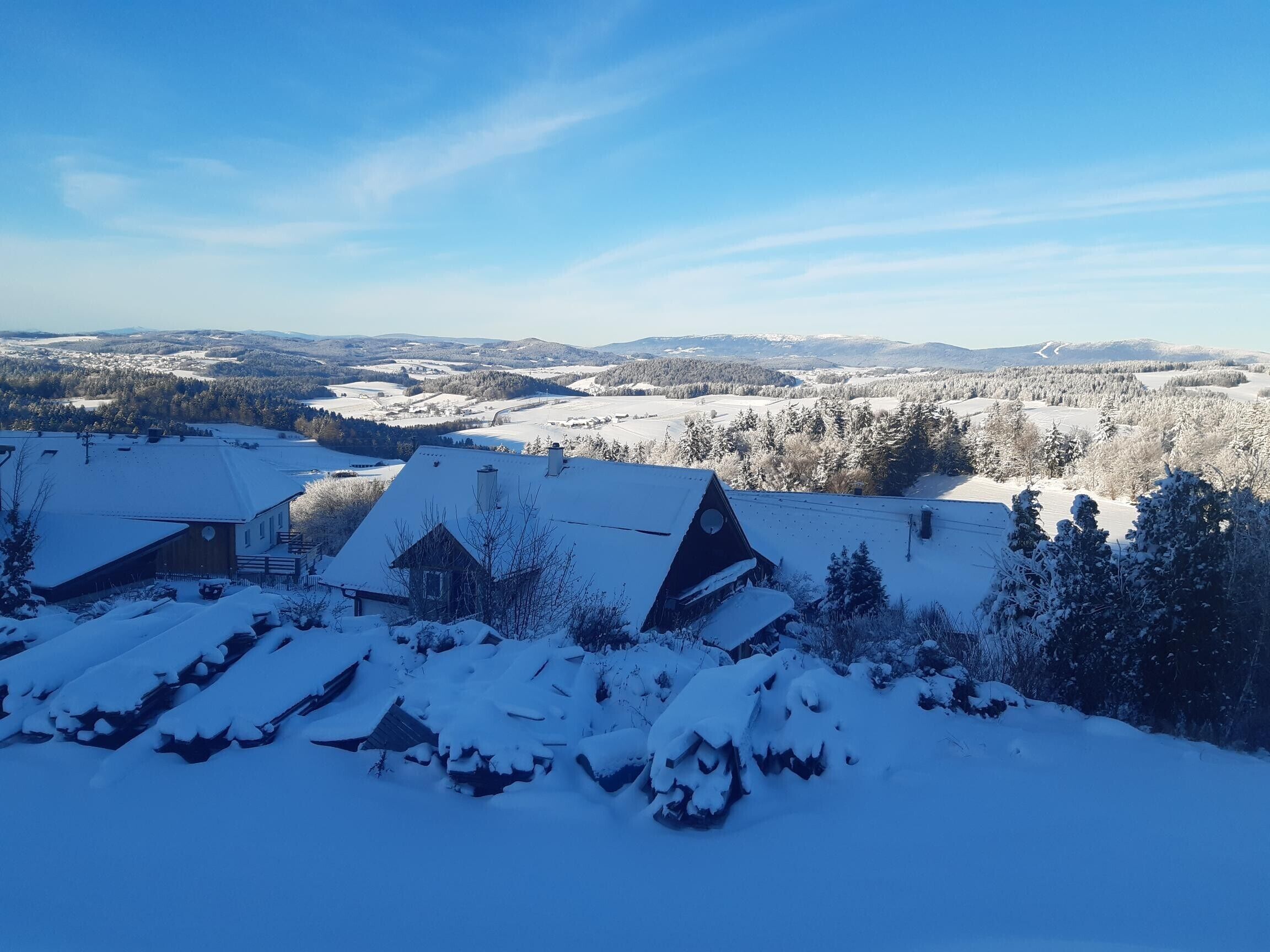 Un paysage enneigé avec des bâtiments et un ciel dégagé.