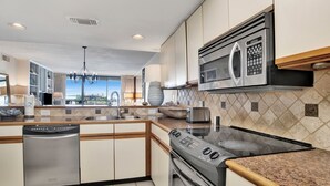 A modern kitchen with stainless steel appliances, a dishwasher, and a granite countertop.