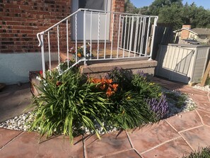 A brick house with a white metal staircase leading to a porch.