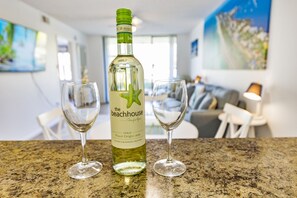 Een fles The Beachhouse Pinot Grigio 2020 wijn op een keukentafel met twee wijnglazen.
