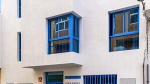 Un edificio moderno con ventanas de marco azul y un letrero que dice "KEANOS".