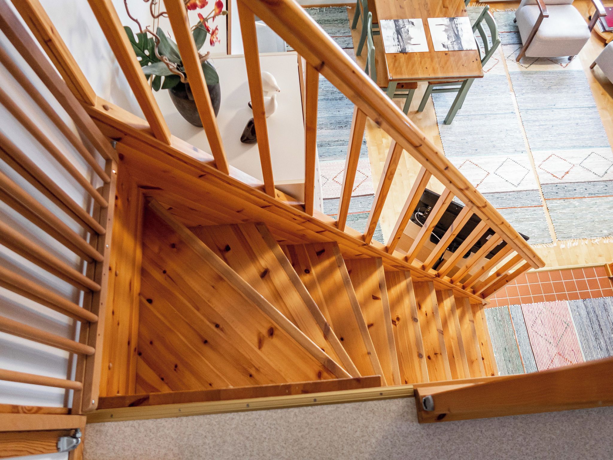 A wooden staircase with a view of a room below.