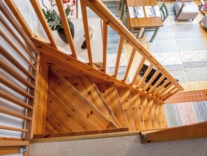 Una escalera de madera con vista a una habitación abajo.