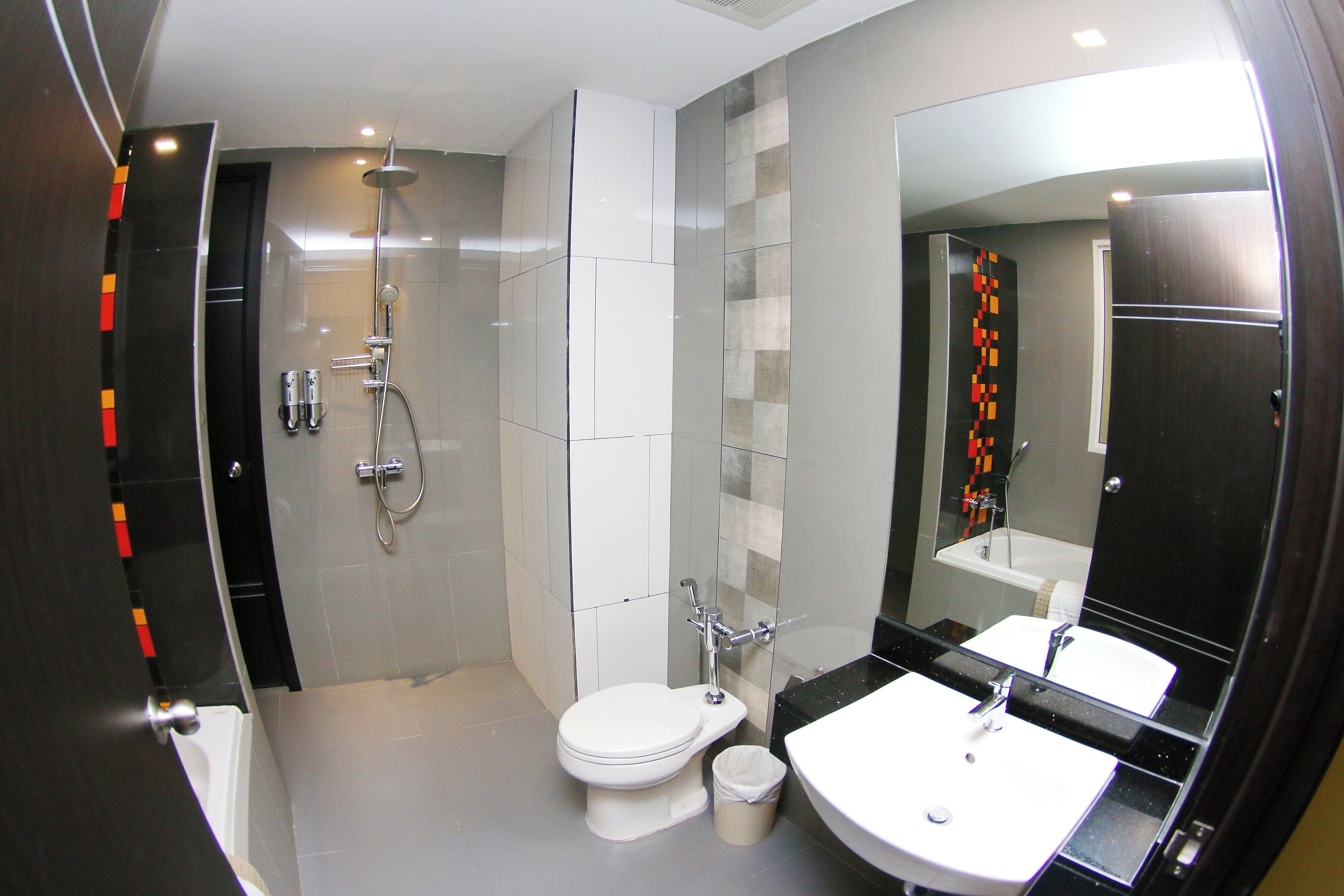 A modern bathroom with a shower, toilet, and sink.