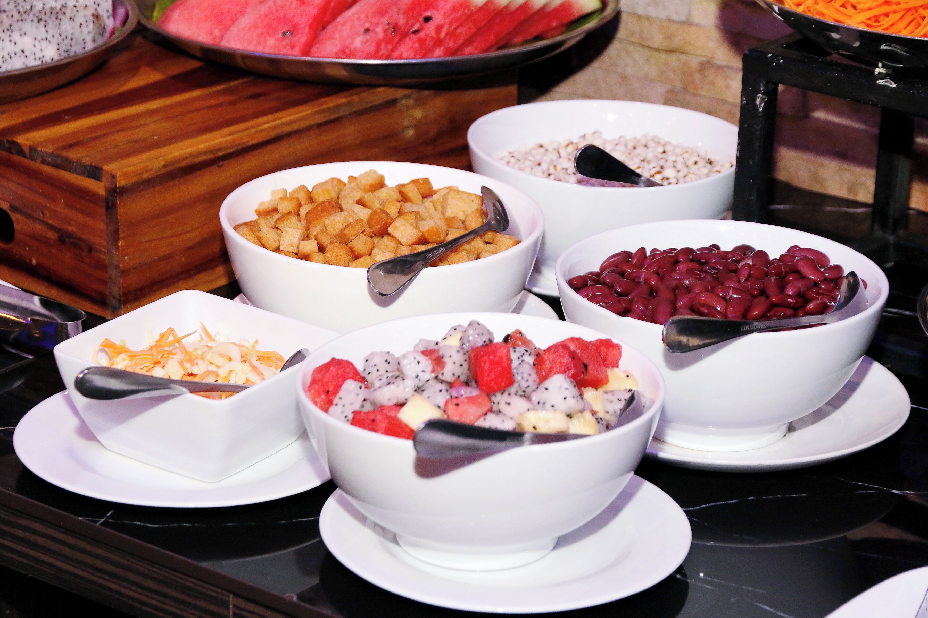 A buffet with various food items including fruits, vegetables, and grains.