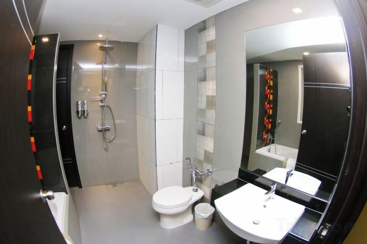 Een moderne badkamer met toilet, wastafel en douche.