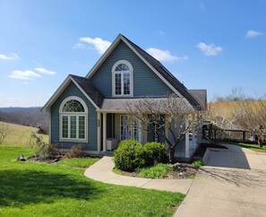 A two-story house with a front porch, a garage, and a well-maintained lawn.