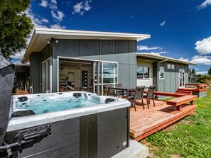 Et moderne hus med jacuzzi, udendørs siddepladser og en terrasse.