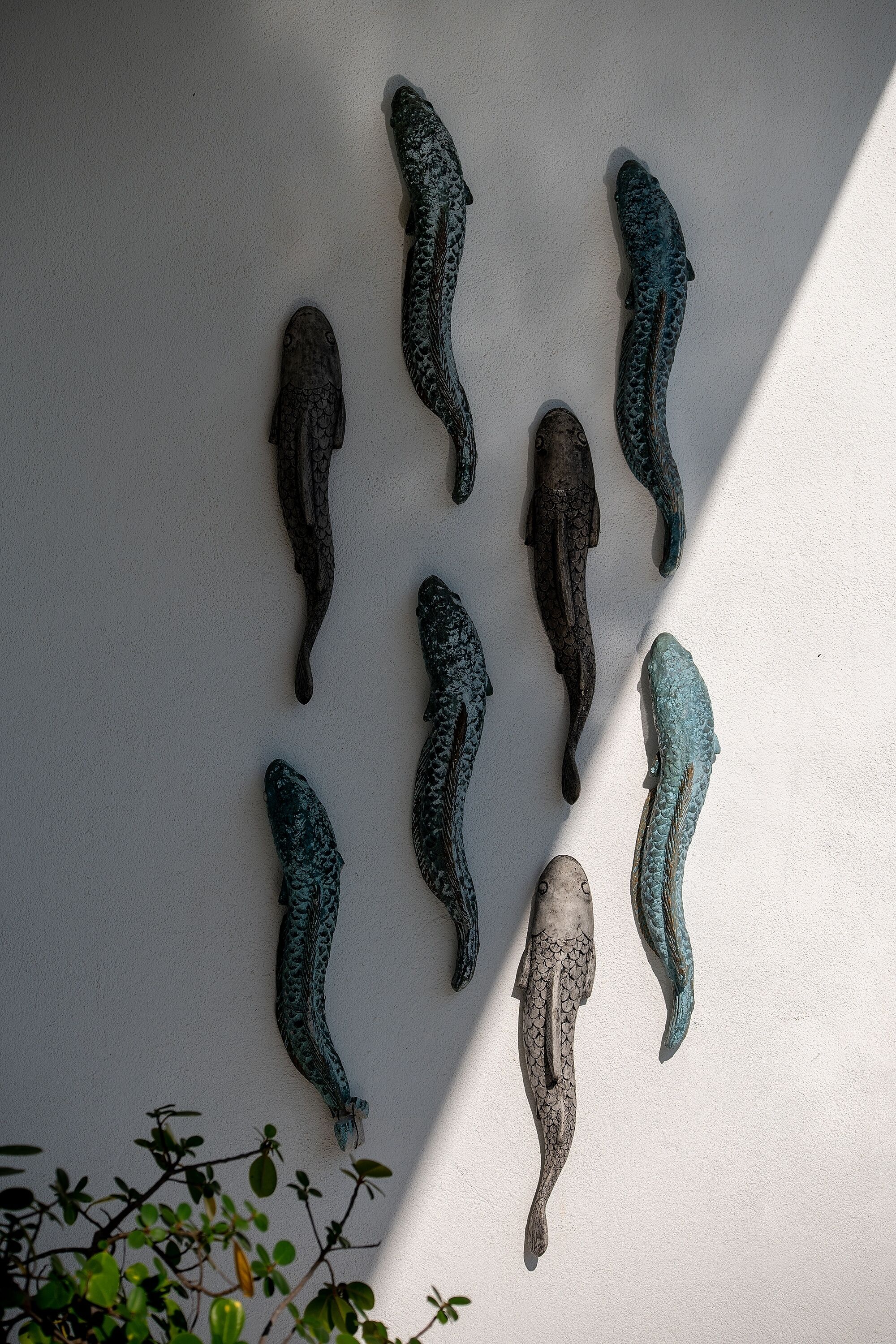 Fiskeskulpturer på en væg.