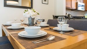 A dining table set with white bowls, plates, and wine glasses, with a vase of white flowers in the center. - ♥︎ Disney-3 miles ♥︎ Private HotTub ♥︎Top Resort♥︎ (Kissimmee)