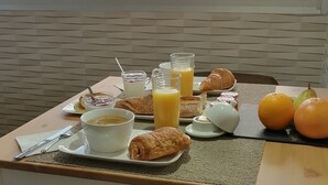 A breakfast tray with croissants, orange juice, and a bowl of soup, set against a backdrop of a mountain view. - Lapausedegout (Lachapelle-Auzac)