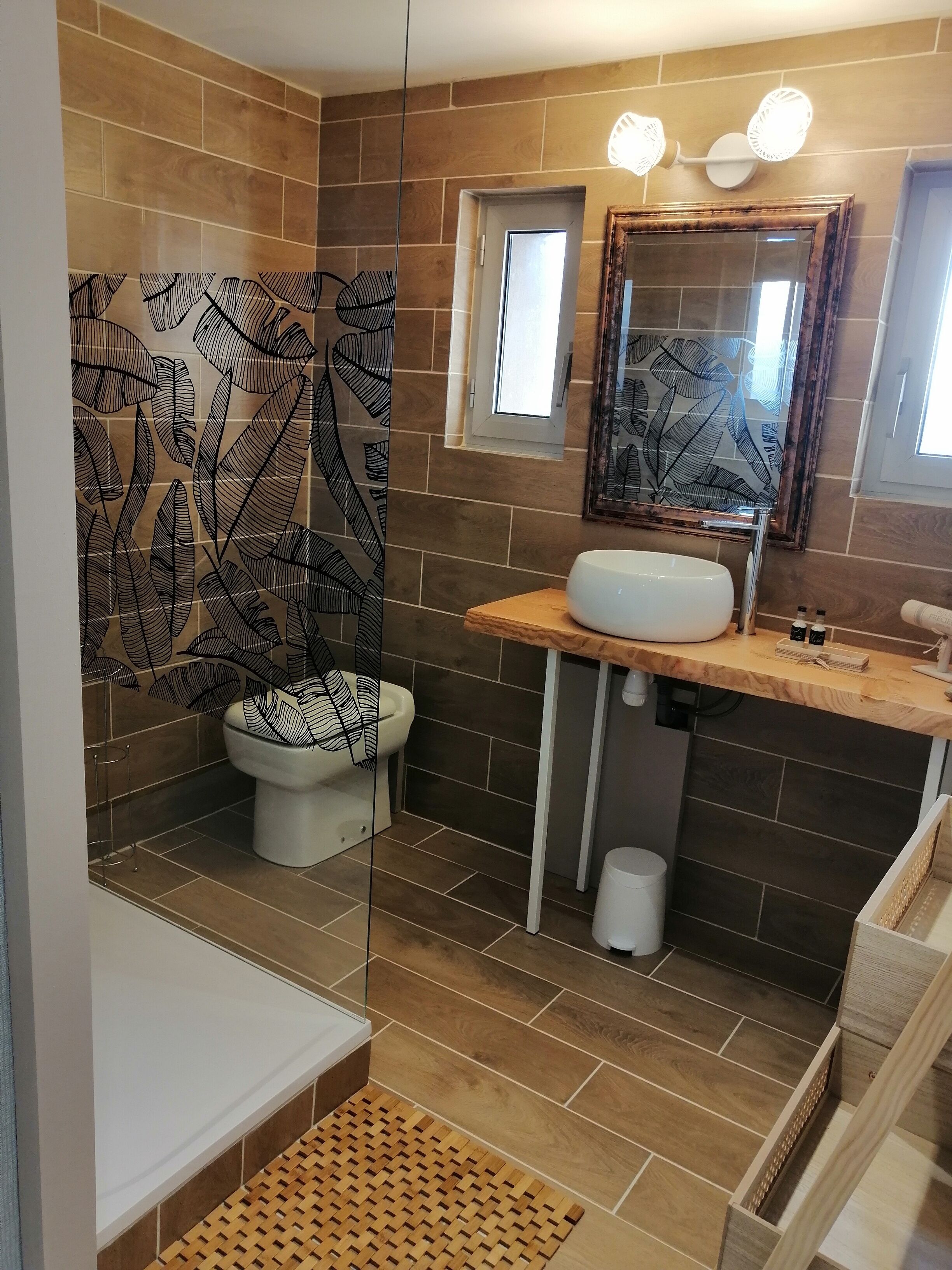 A bathroom with a toilet, sink, and mirror.