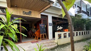 Restaurante llamado 'Serene' con toldo de bambú, un letrero que indica la obligatoriedad de usar mascarilla para entrar y un cartel con la carta.