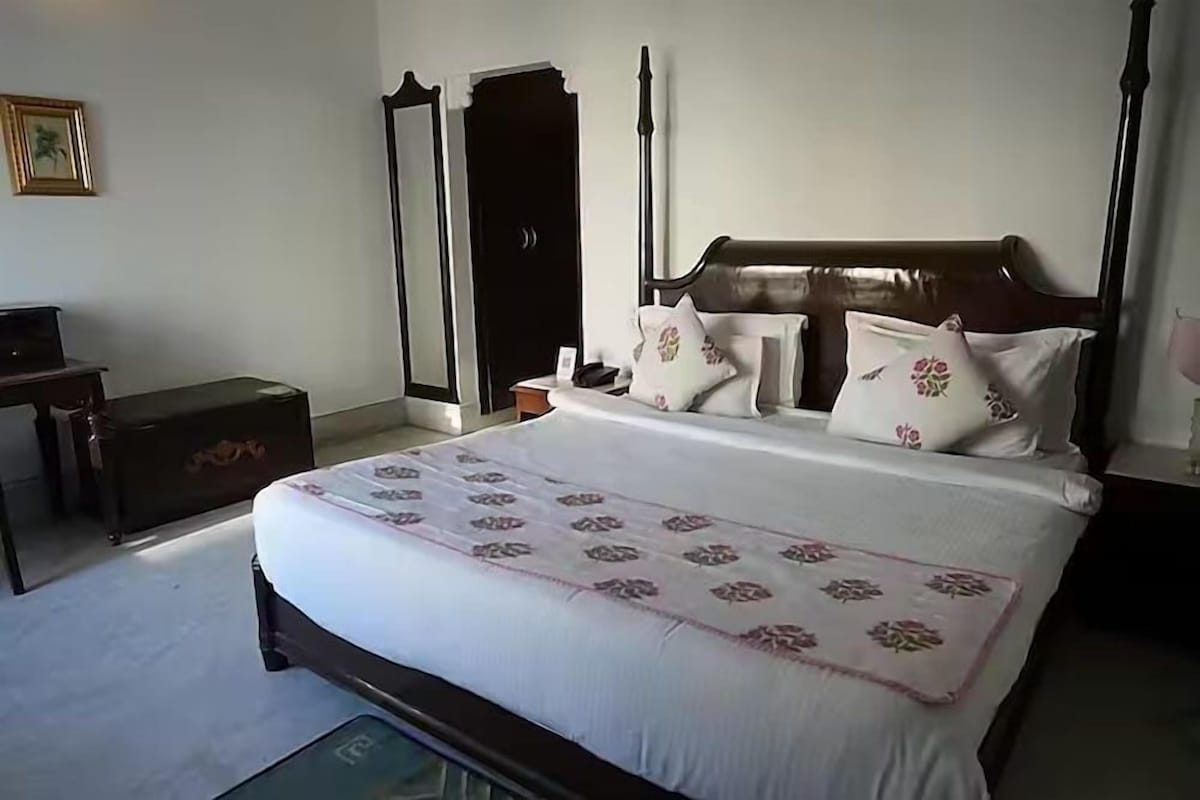 Un dormitorio con una cama grande, un aparador, un armario y una mesita de noche.