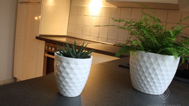 Two white pots with textured patterns on a kitchen counter. - Vacation apartment Dichter & Denker (Weimar)