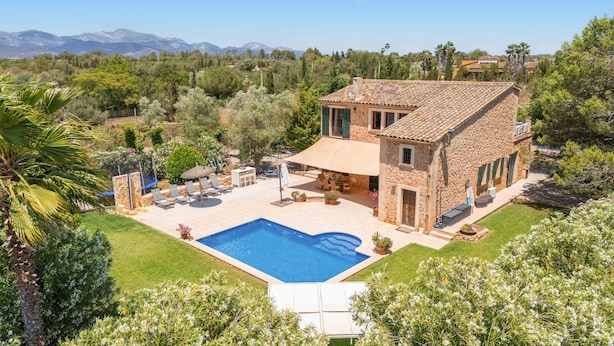 A stone house with a swimming pool, outdoor seating, and a view of mountains. - Country House Finca Kiana with Pool, Garden & Wi-Fi (Sencelles)