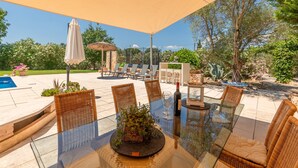 An outdoor patio with a glass table, wicker chairs, a pool, and a pergola. - Country House Finca Kiana with Pool, Garden & Wi-Fi (Sencelles)