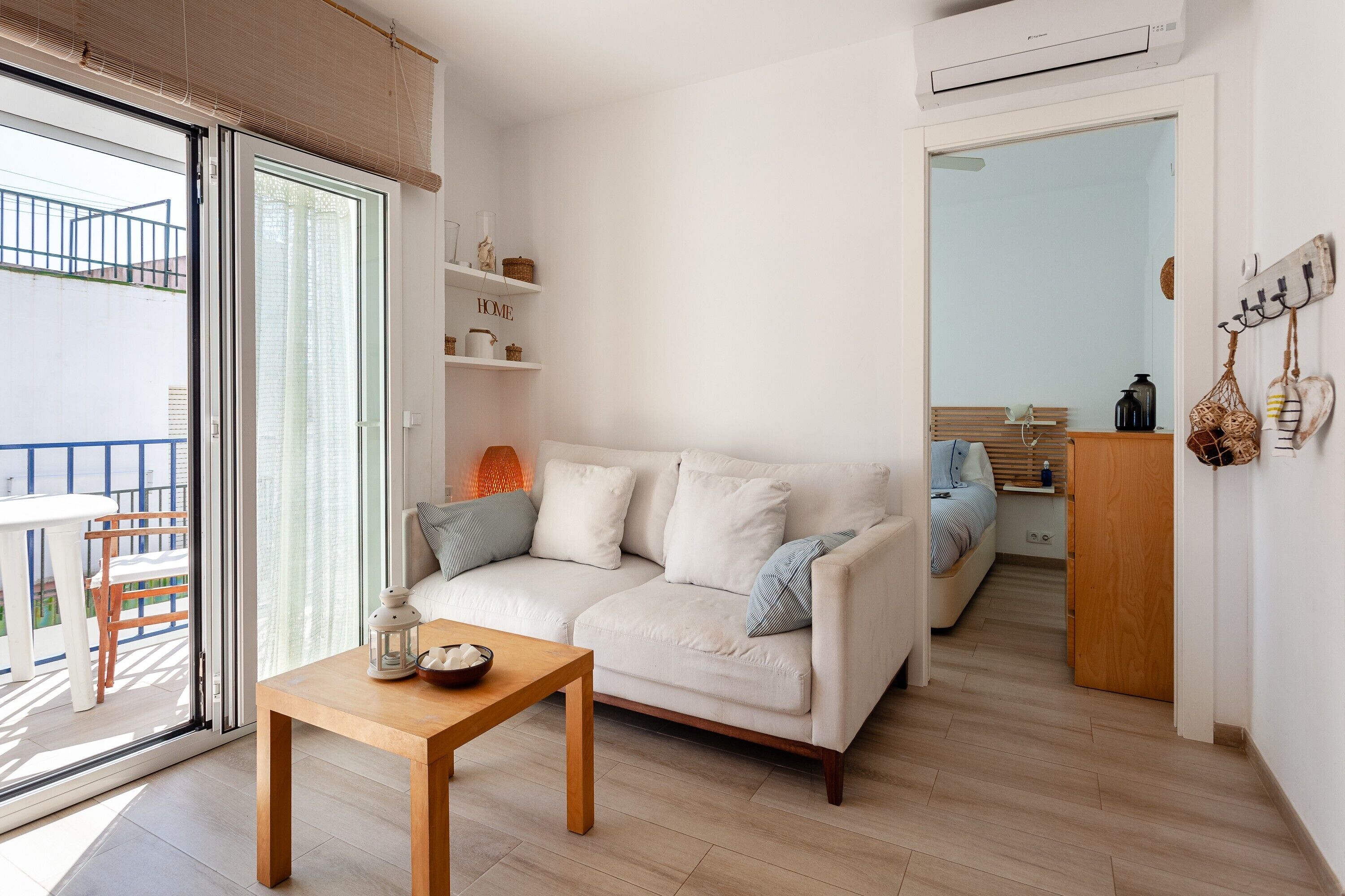 A modern living room with a sofa, a wooden table, and a balcony.
