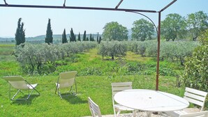 A patio with a round table and four chairs, surrounded by a garden with various plants and trees. - Holiday Home in Murviel with French Garden (Murviel-Les-Beziers)