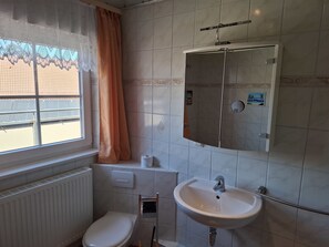Un baño con inodoro, lavamanos y espejo.