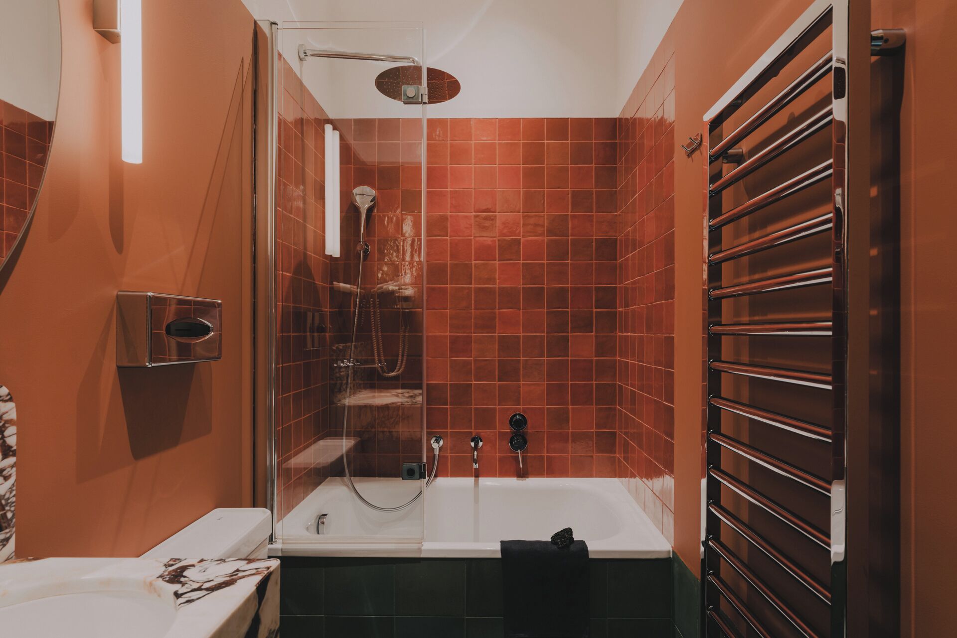 A bathroom with a bathtub, shower, and a towel rack.