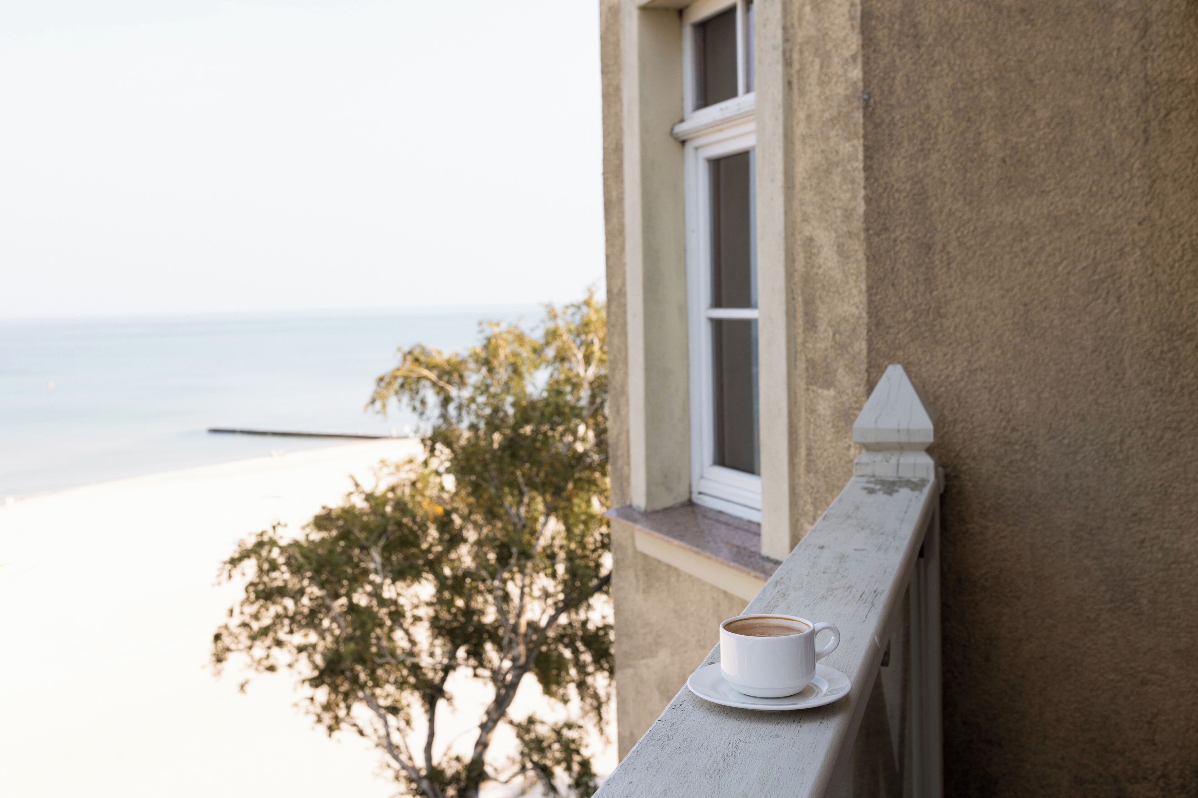 Une tasse de café sur un balcon avec vue sur la mer.