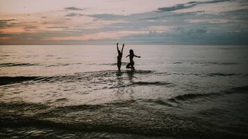 Praia particular, areia branca, espreguiçadeiras, guarda-sóis