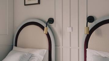 Une chambre d’hôtel avec deux lits, chacun doté d’une tête de lit et d’une lampe de chevet.