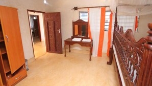 Un dormitorio con cama de madera, un escritorio y un armario.