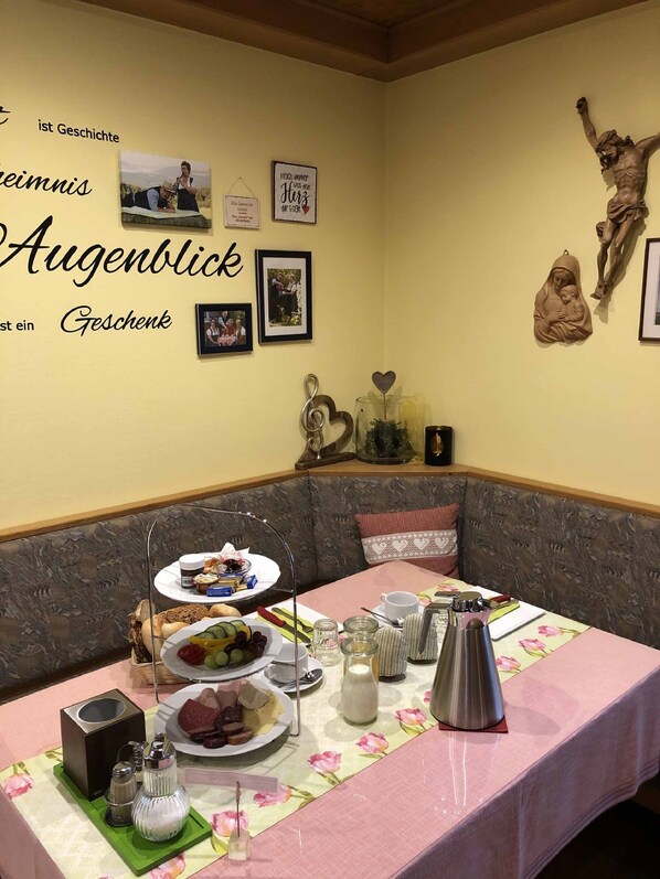 A dining area with a table set for a meal, featuring various dishes and condiments.