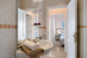 Une salle de bain avec un lavabo, un miroir et une pile de serviettes.