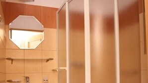 A bathroom with a white sink, a mirror, a shower enclosure, and a toilet. - BELWEDER (Duszniki Zdroj)