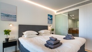 A modern hotel room with a large bed, bedside tables, a small plant, and artwork on the walls. - "Apartment Higueron Wave 1" with Sea View, Pool, Wi-Fi & Terrace (Fuengirola)