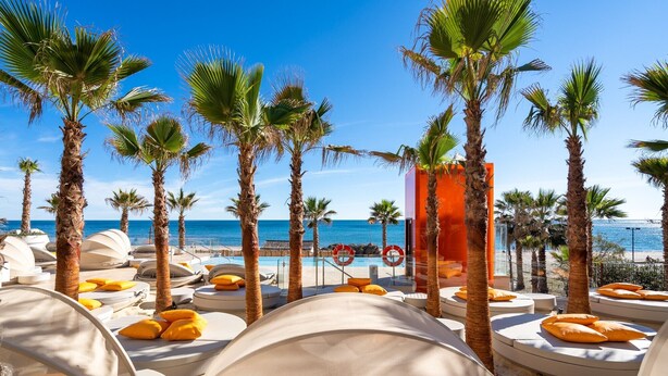A beachside resort with sun loungers, palm trees, and a clear view of the ocean. - "Apartment Higueron Wave 1" with Sea View, Pool, Wi-Fi & Terrace (Fuengirola)