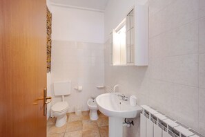 A bathroom with a toilet, bidet, and sink.
