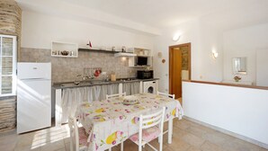 A compact kitchen with a refrigerator, microwave, and sink. There is a dining table with chairs and a window with a view. - Holiday Home "Casetta Antonella" with Mountain View, Garden & Terrace (Fraz. Lecchiore comune Dolcedo)
