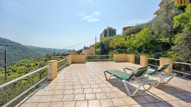 A terrace with a view of a hilly landscape, a building with a yellow facade, and a stone wall. - Holiday Home "Casetta Antonella" with Mountain View, Garden & Terrace (Fraz. Lecchiore comune Dolcedo)