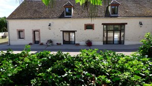 Un bâtiment à deux étages, doté d’un toit en pente, de nombreuses fenêtres et d’une grande porte vitrée.