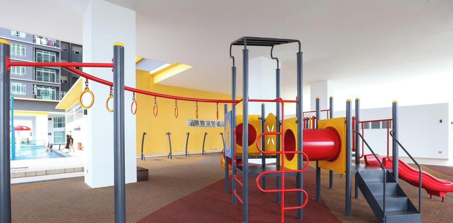 A playground with a slide, climbing structures, and a pool area.