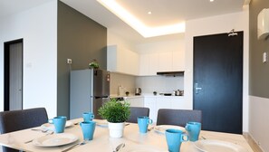 A modern kitchen with white cabinets, a built-in oven, and a black door. - NOVO 8 Jonker Street Melaka By I Housing (Malacca City)
