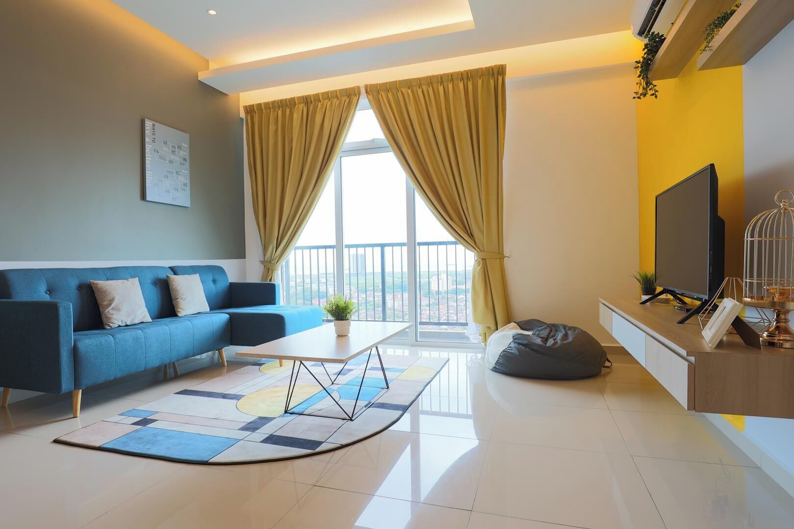 A modern living room with a blue sofa, a coffee table, and a TV on a wooden stand.