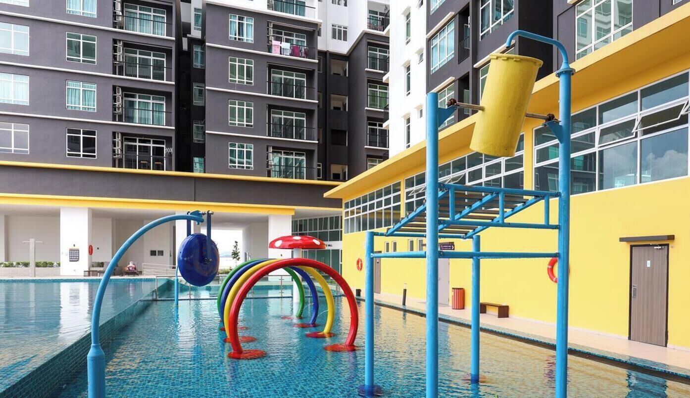 Ein hallenbad mit blau-gelber Farbgebung, umgeben von einem mehrstöckigen Gebäude mit Balkonen.