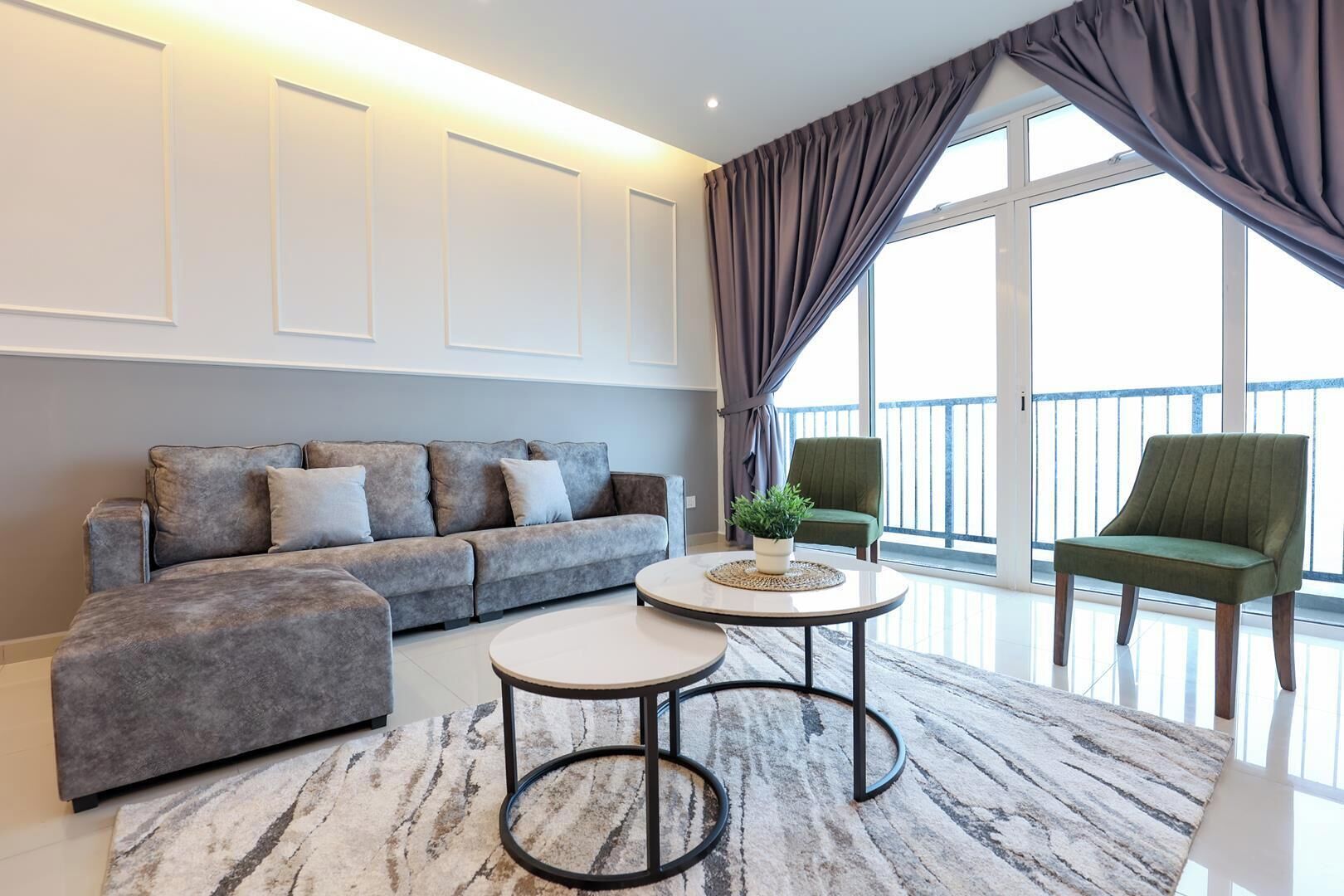 A modern living room with a grey sofa, two armchairs, a coffee table, and a large window with curtains.