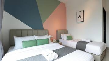 A hotel room with two beds, a large geometric wall design, a framed picture, and a neatly made bed with towels.