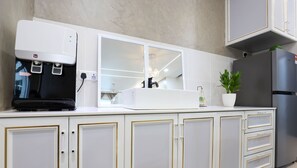 A modern kitchen with white cabinetry, a built-in coffee machine, a sink, and a refrigerator. - NOVO 8 Jonker Street Melaka By I Housing (Malacca City)