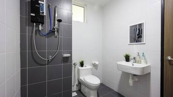 Une salle de bain moderne équipée de toilettes, d’un lavabo et d’une douche.