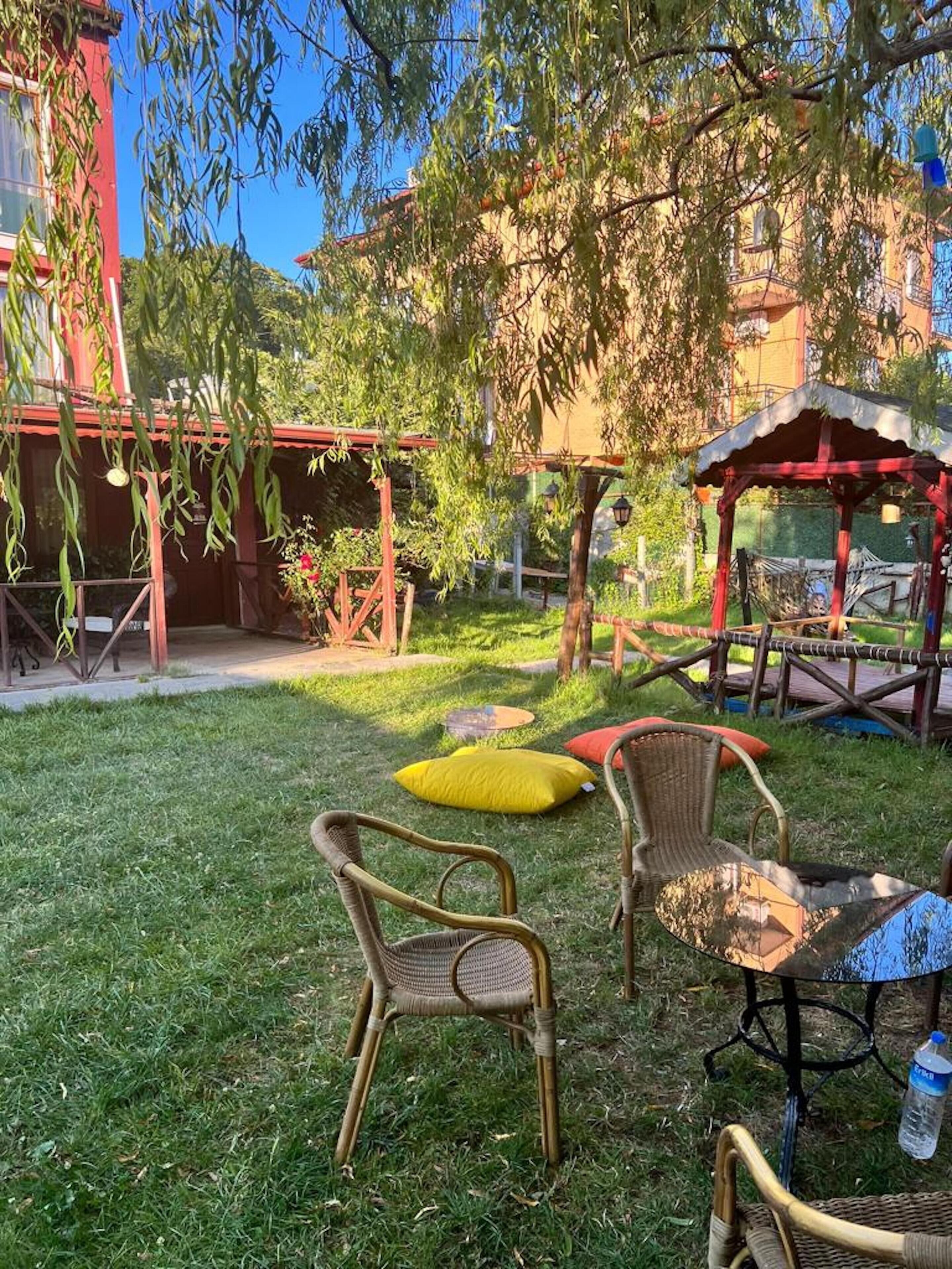 A grassy outdoor area with wicker furniture, a small table, and a gazebo.