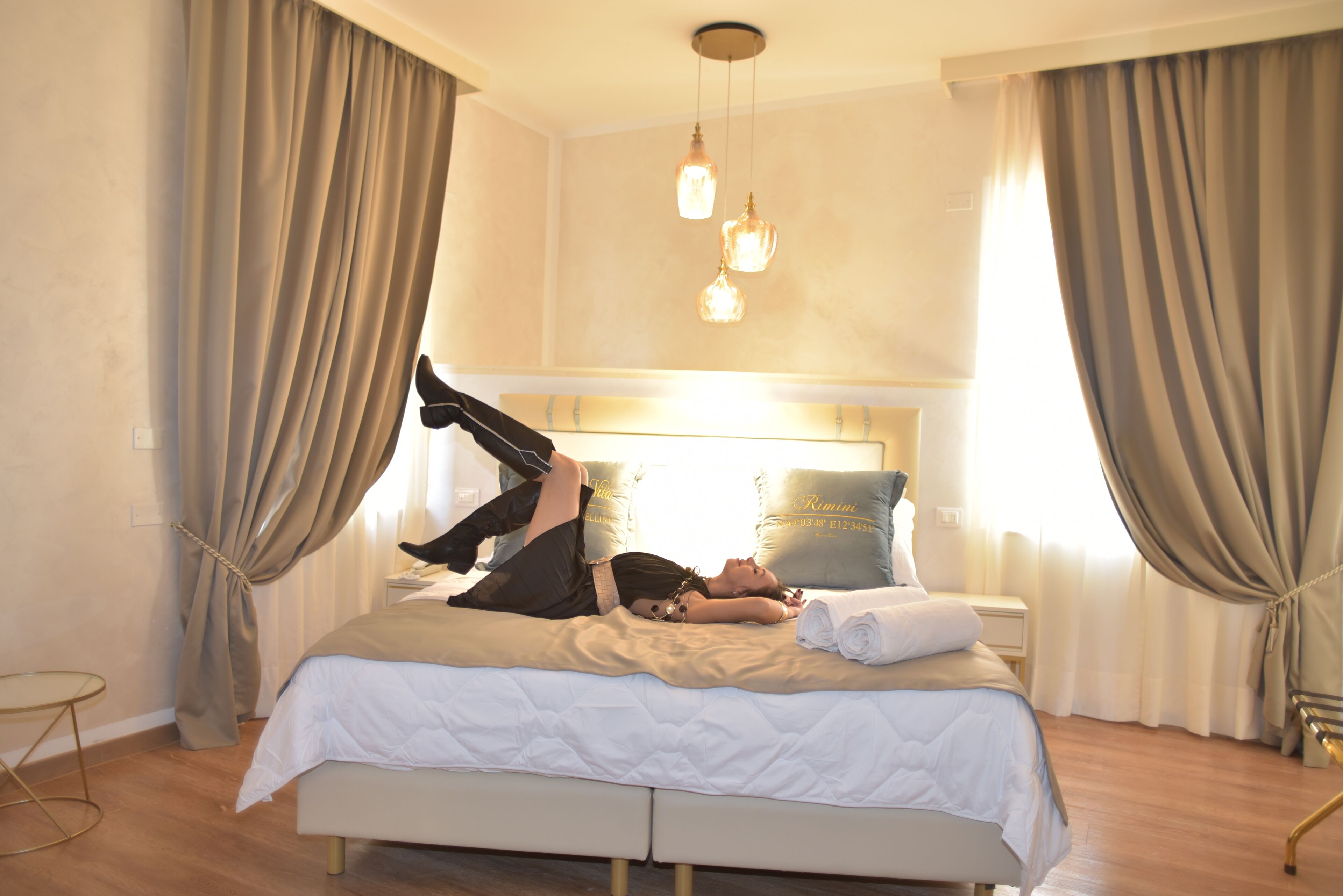 A bed with a white duvet, a bedside table, and a lamp.
